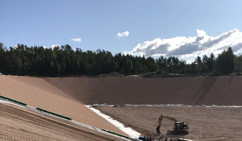 Bulldoser og gravemaskin i arbeid med å klargjøre en ny, moderne deponicelle